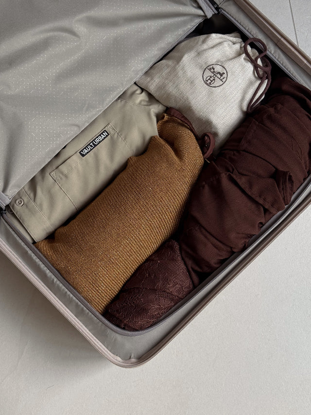 Vault Urban performance shirt neatly folded inside a suitcase, ready for travel alongside knitwear and essentials