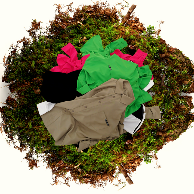 Vault Urban sustainable wrinkle-free shirts in beige, green, pink, black, and white, displayed on natural moss background to highlight biodegradability and eco-friendly design